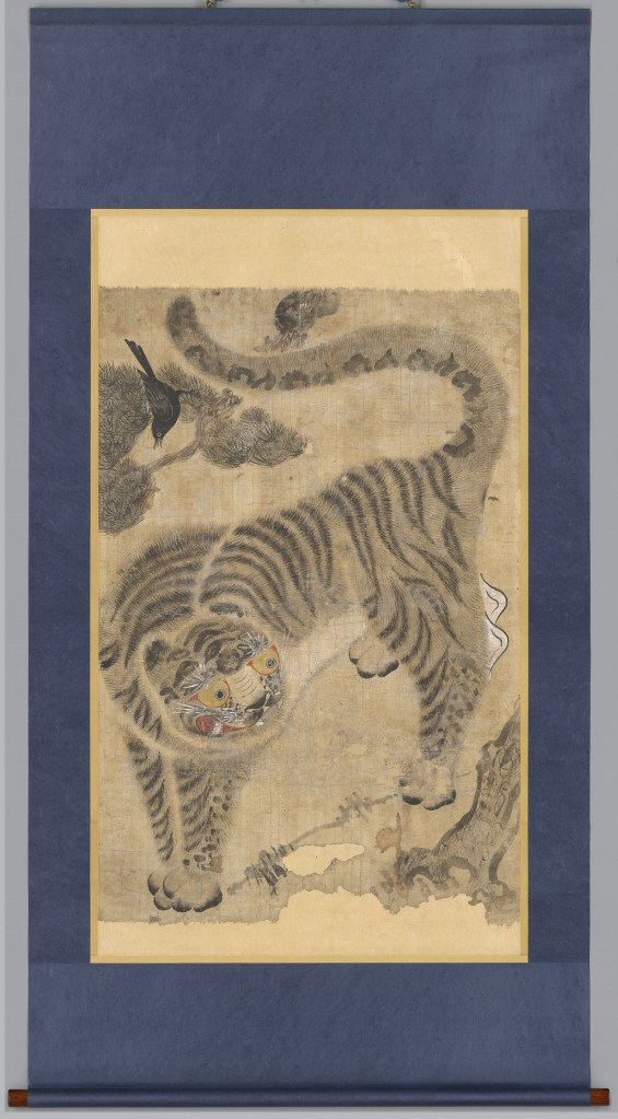 Traditional Korean folk painting of a tiger, with a whimsical expression and stylized features, surrounded by a simple background.